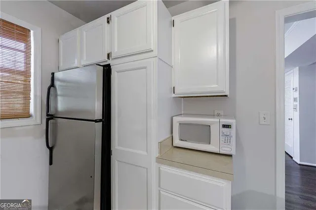 a kitchen with a refrigerator and a stove top oven