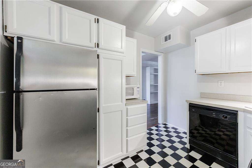 3660 Peachtree Road Northeast, Unit 2H Atlanta, GA 30319 - Photo 18 of 56 a kitchen with a refrigerator and a stove top oven