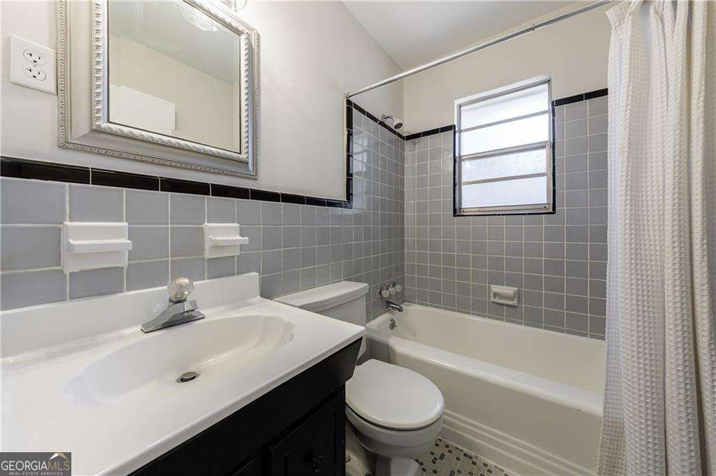 3660 Peachtree Road Northeast, Unit 2H Atlanta, GA 30319 - Photo 20 of 56 a bathroom with a bathtub shower sink vanity mirror and toilet