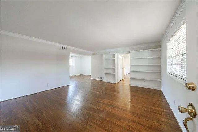a street view with large trees and flower plants