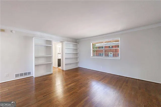a view of empty room with wooden floor and windows