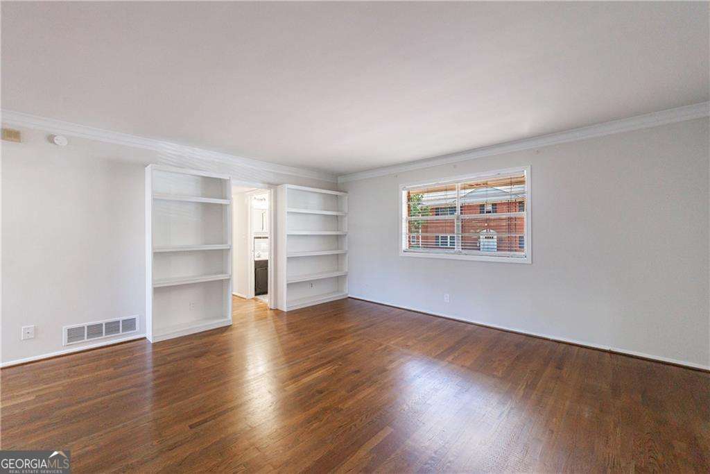 3660 Peachtree Road Northeast, Unit 2H Atlanta, GA 30319 - Photo 7 of 56 a view of an empty room with a window and wooden floor