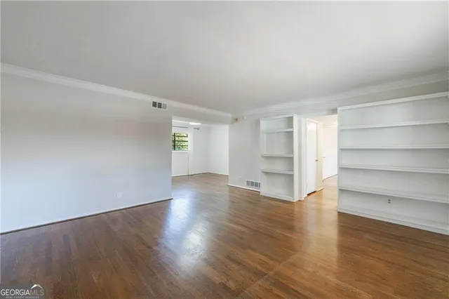 a view of a room with wooden floor and a window
