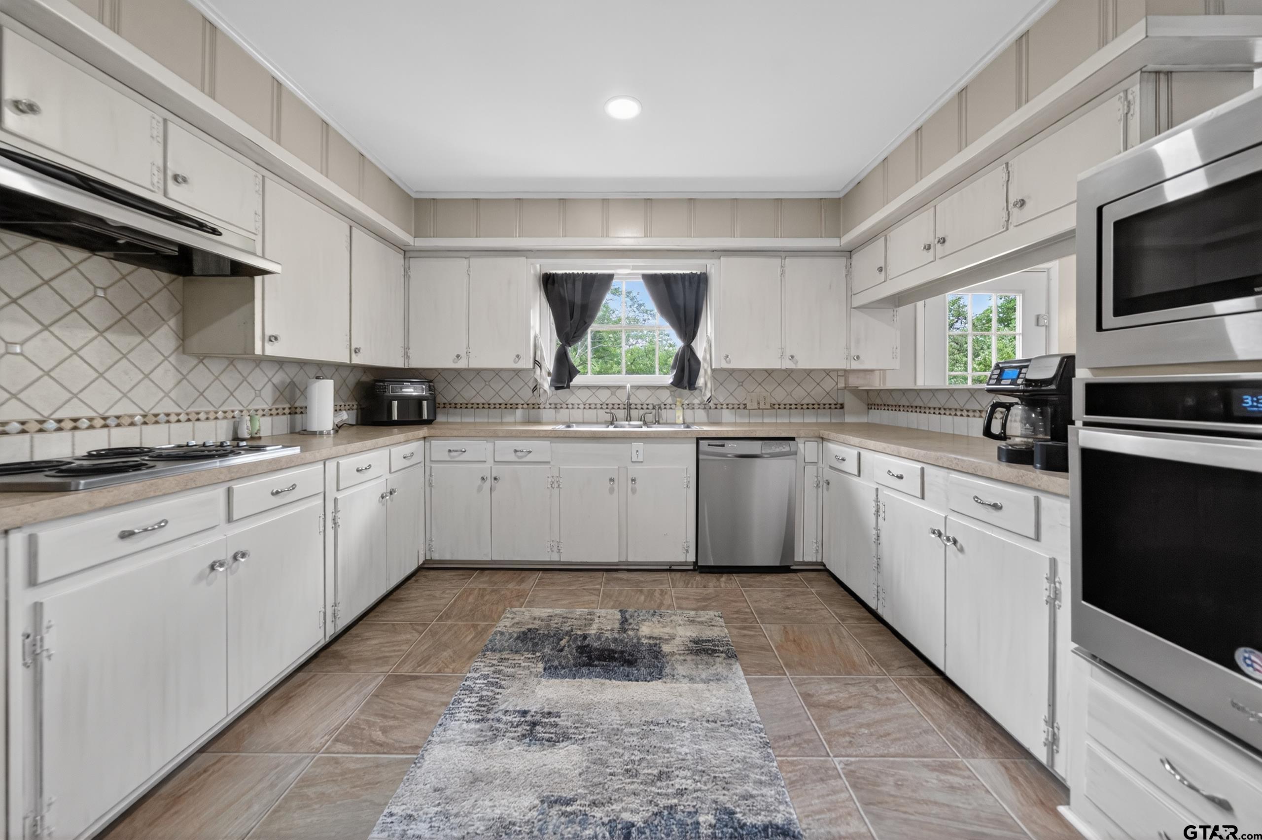 720 Wilma Street Tyler, TX 75701 - Photo 12 of 41 a kitchen with a sink cabinets appliances and a window