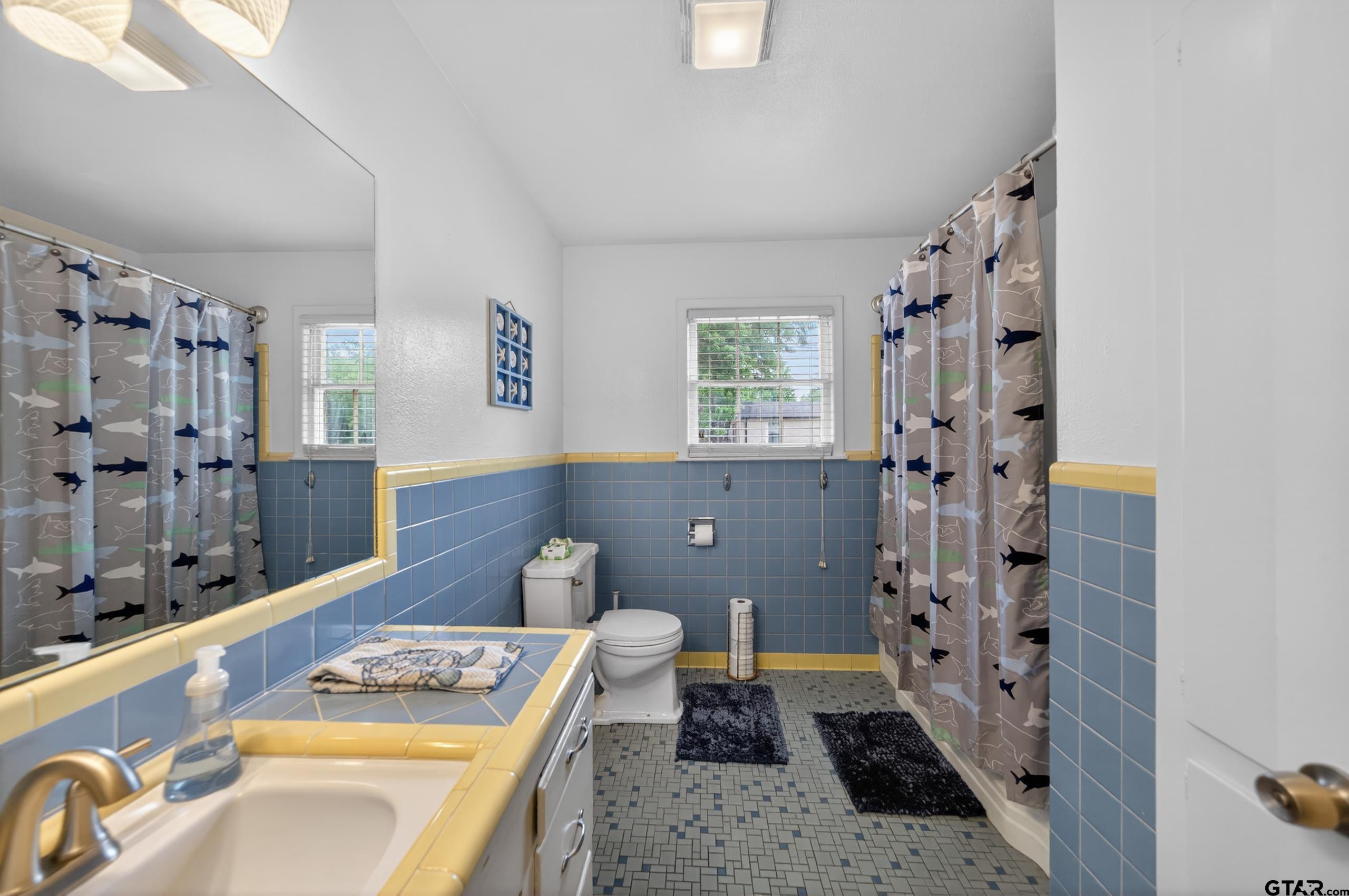 720 Wilma Street Tyler, TX 75701 - Photo 21 of 41 a bathroom with a granite countertop sink a mirror a vanity and a shower