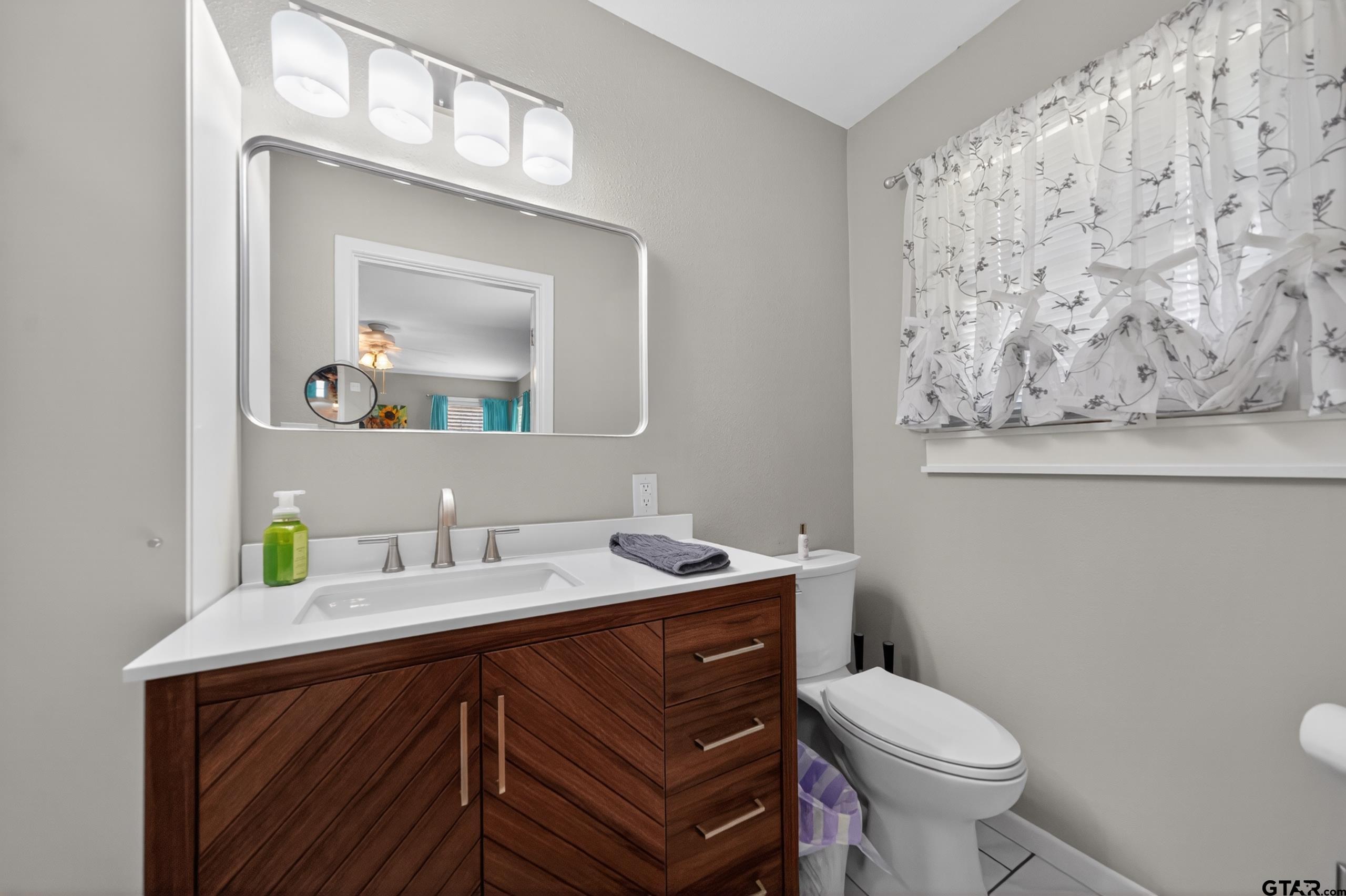 720 Wilma Street Tyler, TX 75701 - Photo 25 of 41 a bathroom with a toilet sink and mirror