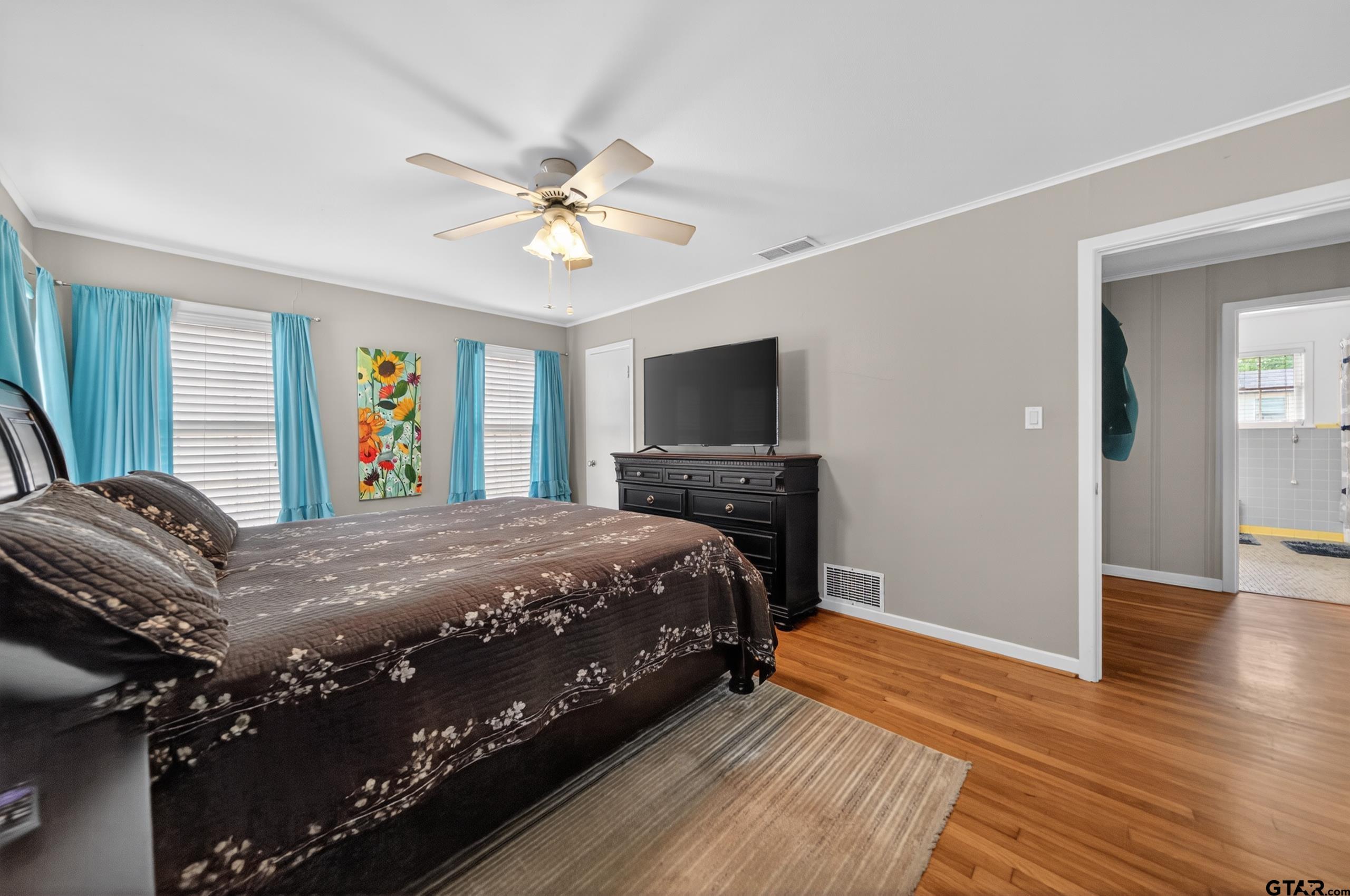 720 Wilma Street Tyler, TX 75701 - Photo 28 of 41 a bedroom with a bed dresser and a flat tv screen