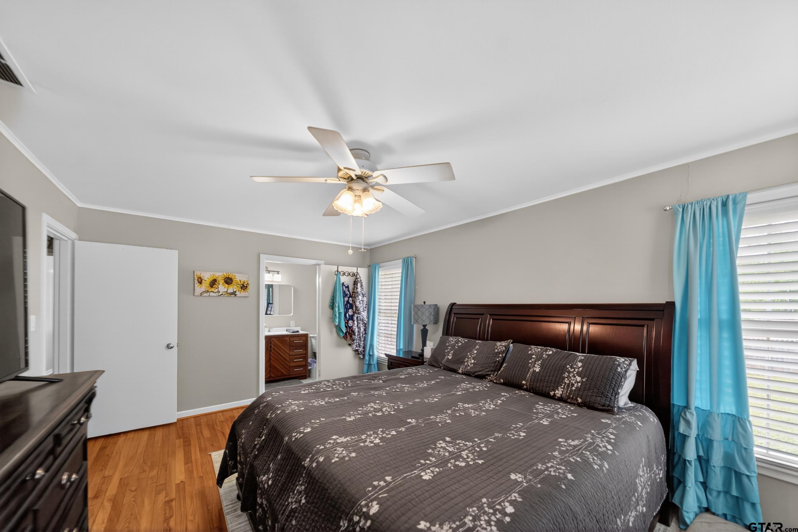 720 Wilma Street Tyler, TX 75701 - Photo 30 of 41 a bedroom with a large bed and a chandelier