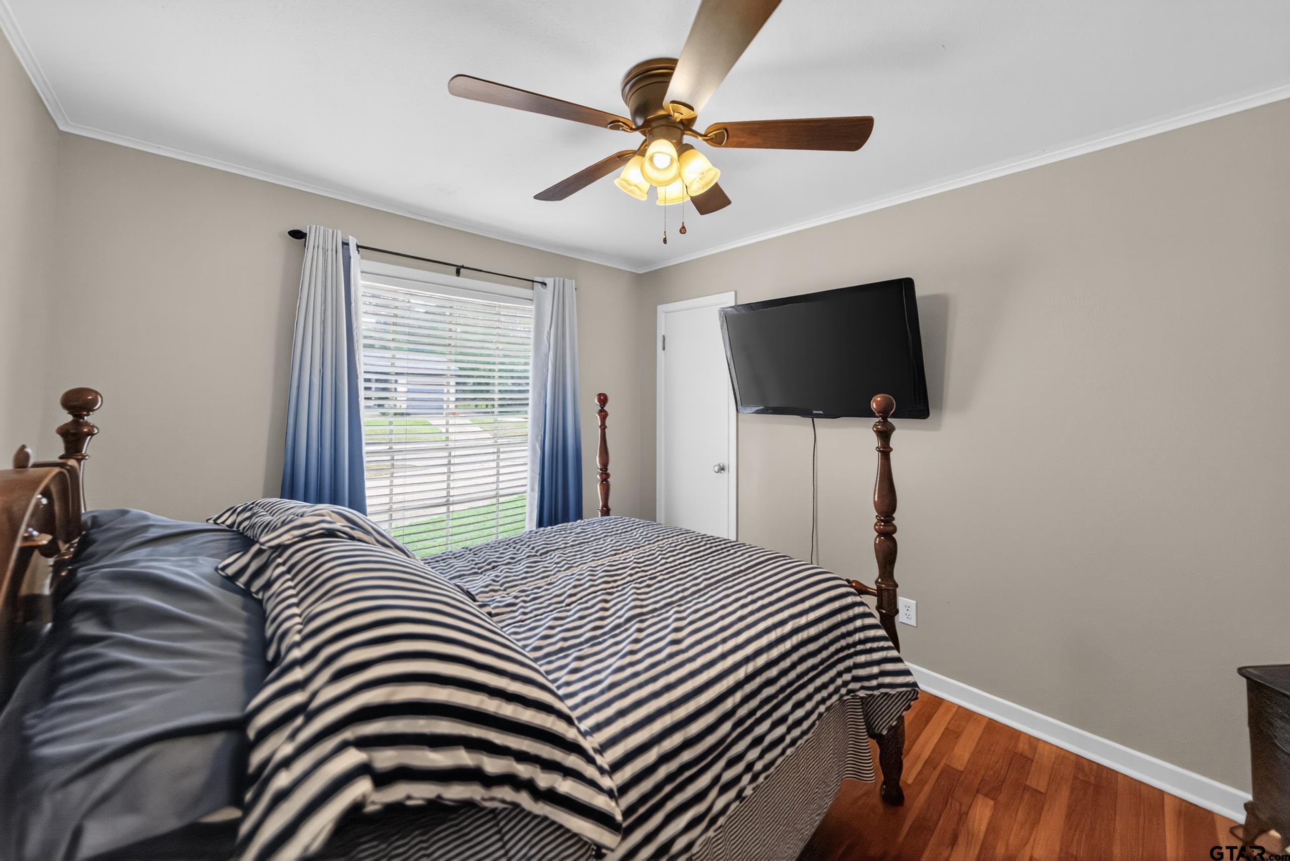 720 Wilma Street Tyler, TX 75701 - Photo 31 of 41 a bedroom with a bed and a flat screen tv