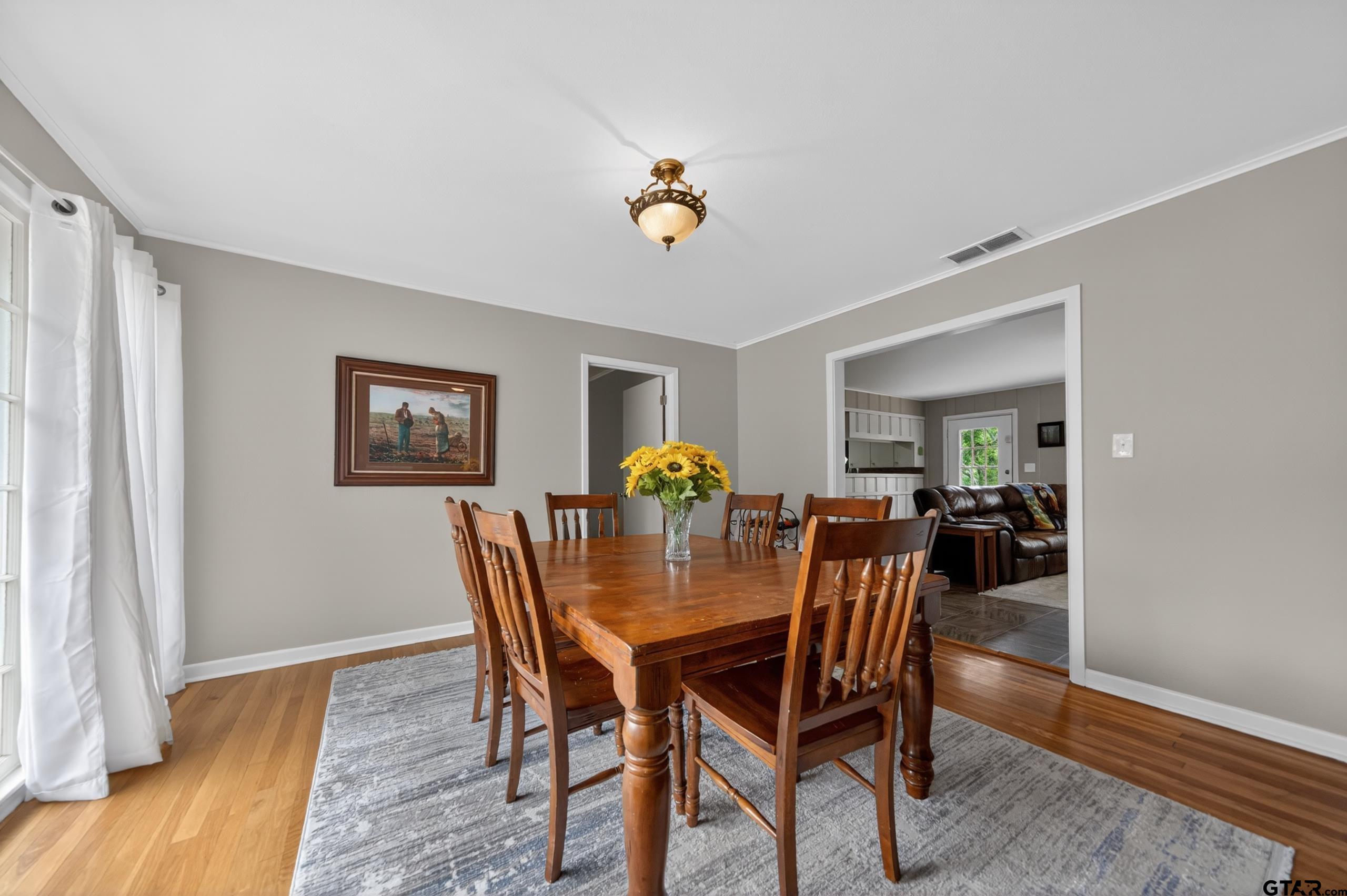 720 Wilma Street Tyler, TX 75701 - Photo 7 of 41 a dining room with furniture and wooden floor a chandelier
