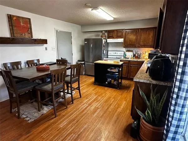 a kitchen with a table chairs and wooden floor