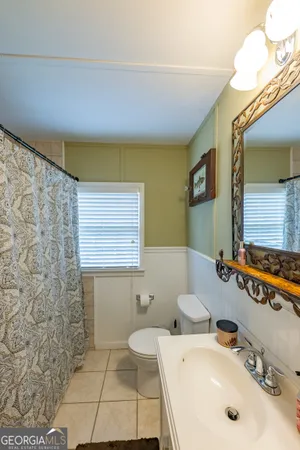 a bathroom with a sink a toilet and mirror