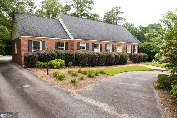 a front view of a house with a yard and a garden