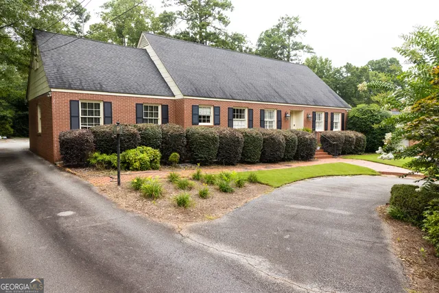 a front view of a house with a yard and a garden