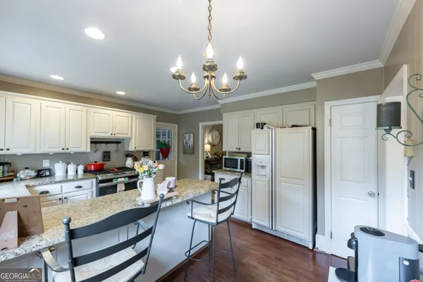 a kitchen that has a lot of cabinets a sink and appliances