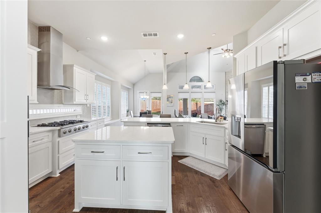 7705 Falcon Ridge Road Denton, TX 76208 - Photo 5 of 40 Kitchen with a center island, backsplash, white cabinetry, and a peninsula