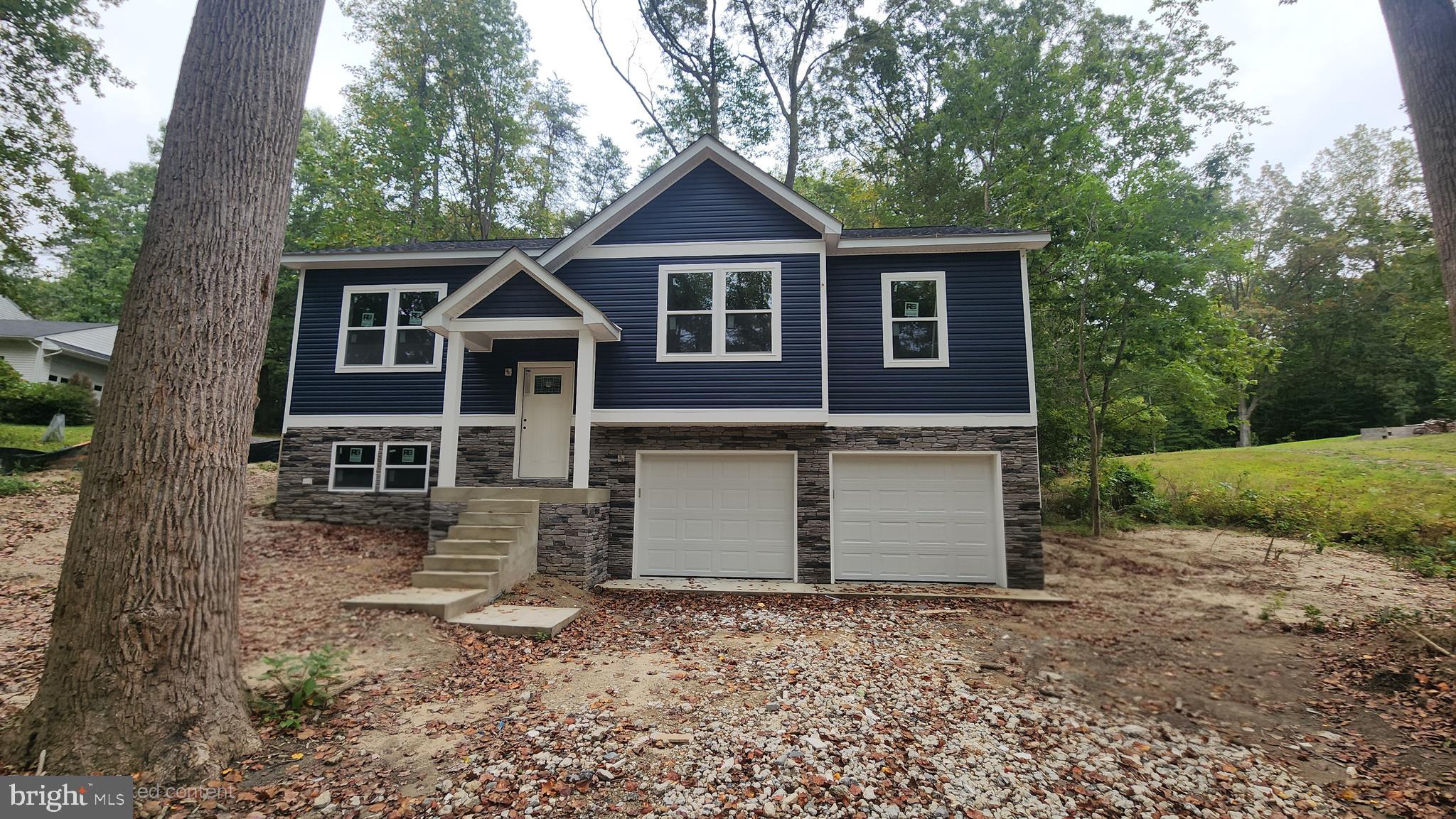 23570 Myrtle Point Road California, MD 20619 - Photo 2 of 10 a front view of a house with a yard and garage