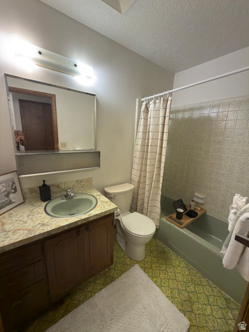 1164 East Mountain Road Logan, UT 84321 - Photo 44 of 45 Bathroom featuring a vanity with a light-colored countertop, an integrated sink, and wood cabinetry