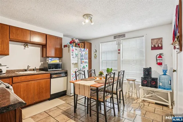 a kitchen with stainless steel appliances kitchen island granite countertop a table and chairs in it