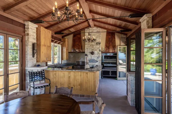 a view of a patio with chairs and a table under an umbrella