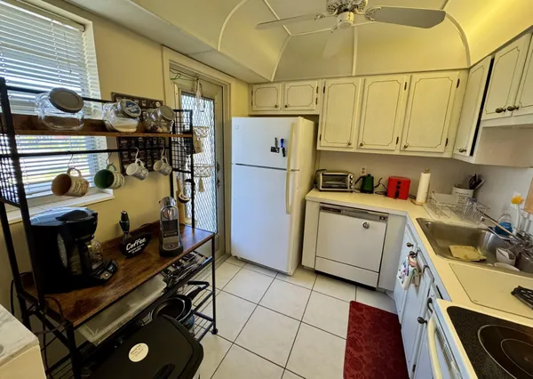 a kitchen with a refrigerator and a stove top open