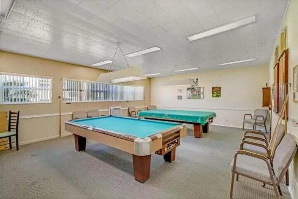 a room with pool table and windows