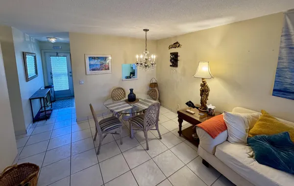 a living room with furniture a chandelier and a dining table