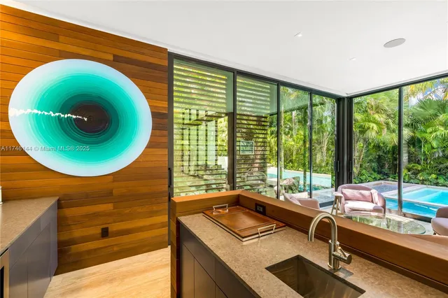 a living room with furniture floor to ceiling window and a flat screen tv