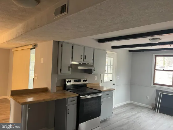 a kitchen with a refrigerator a sink dishwasher stove and white cabinets