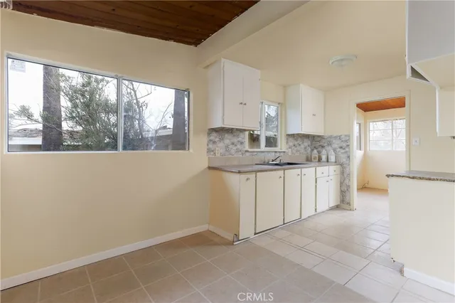 a kitchen with a sink window and cabinets