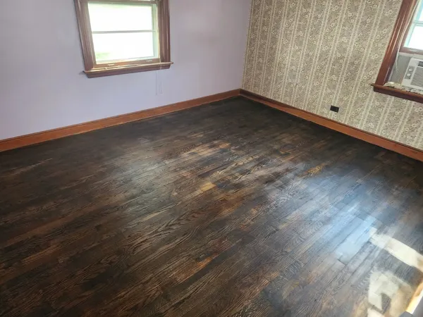 a view of a room with wooden floor and windows