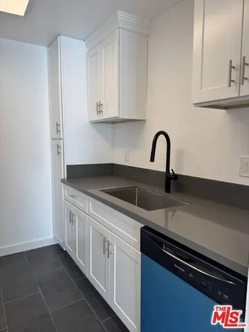 a kitchen with granite countertop a sink and cabinets