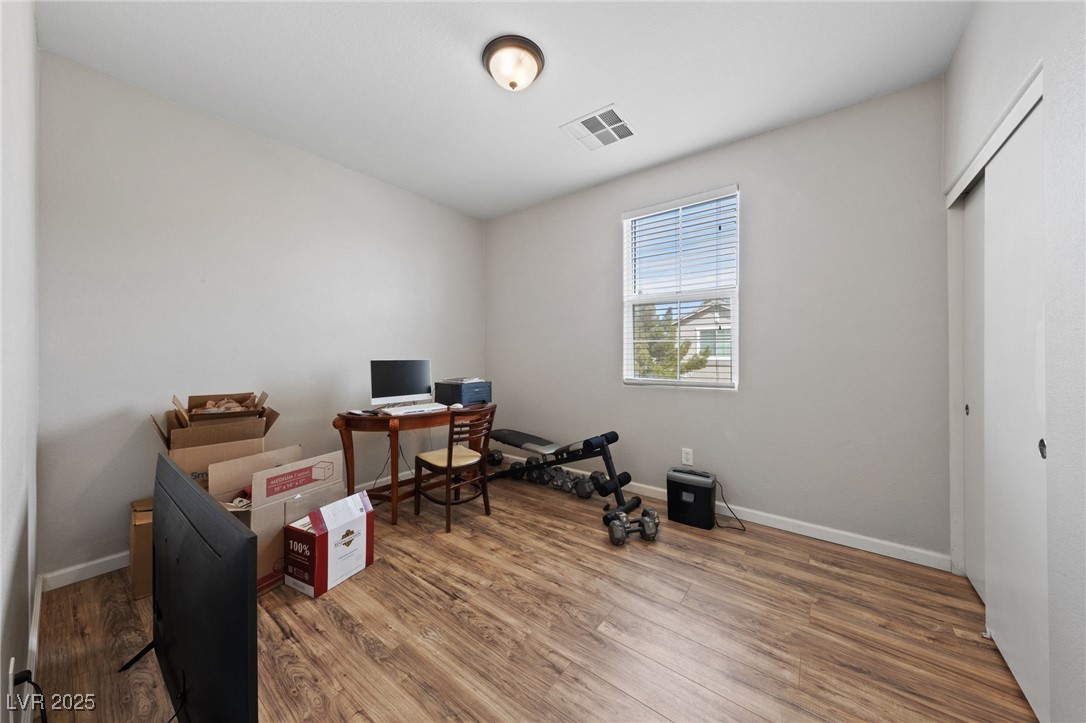 9121 Ripple Ridge Avenue, Unit 101 Las Vegas, NV 89149 - Photo 10 of 16 Home office featuring wood finished floors and baseboards