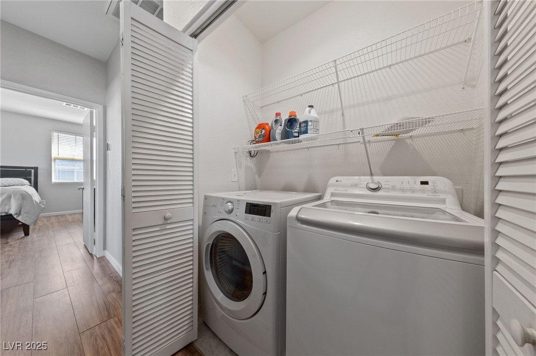9121 Ripple Ridge Avenue, Unit 101 Las Vegas, NV 89149 - Photo 11 of 16 Washroom featuring separate washer and dryer and wood finished floors