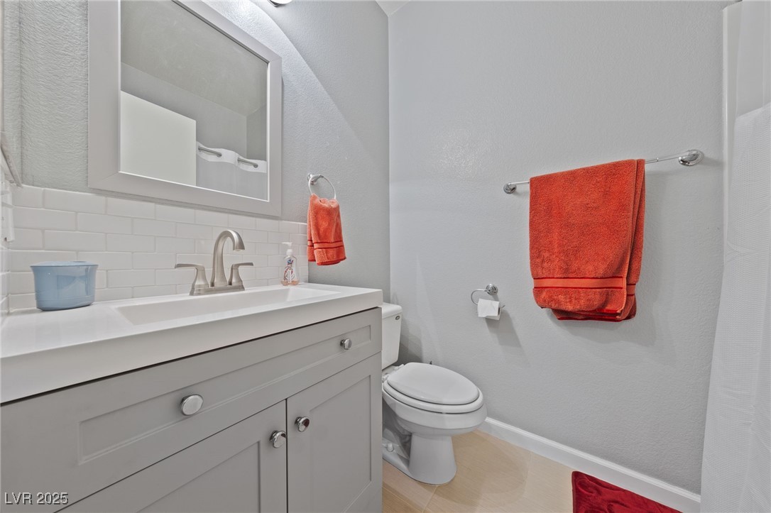 9121 Ripple Ridge Avenue, Unit 101 Las Vegas, NV 89149 - Photo 12 of 16 Bathroom featuring tasteful backsplash and vanity