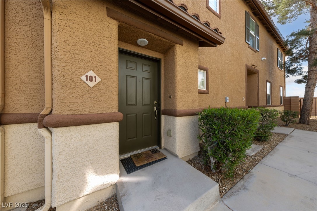 9121 Ripple Ridge Avenue, Unit 101 Las Vegas, NV 89149 - Photo 5 of 16 Doorway to property with stucco siding
