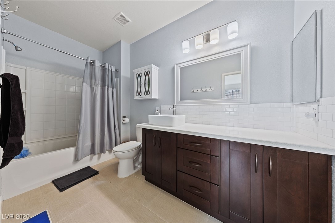 9121 Ripple Ridge Avenue, Unit 101 Las Vegas, NV 89149 - Photo 9 of 16 Full bathroom featuring double vanity, shower / bathtub combination with curtain, and backsplash