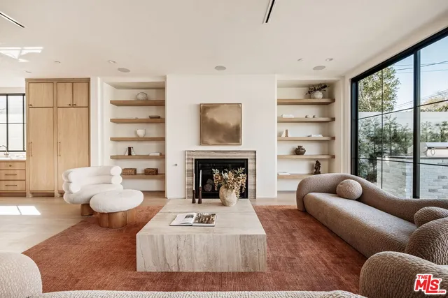 a living room with furniture fireplace and a large window