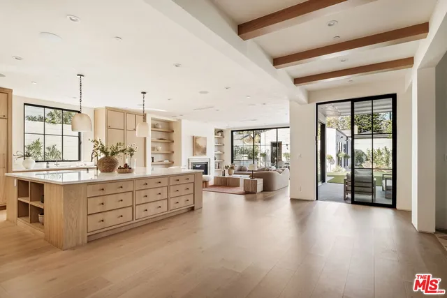 a large white kitchen with granite countertop a large window