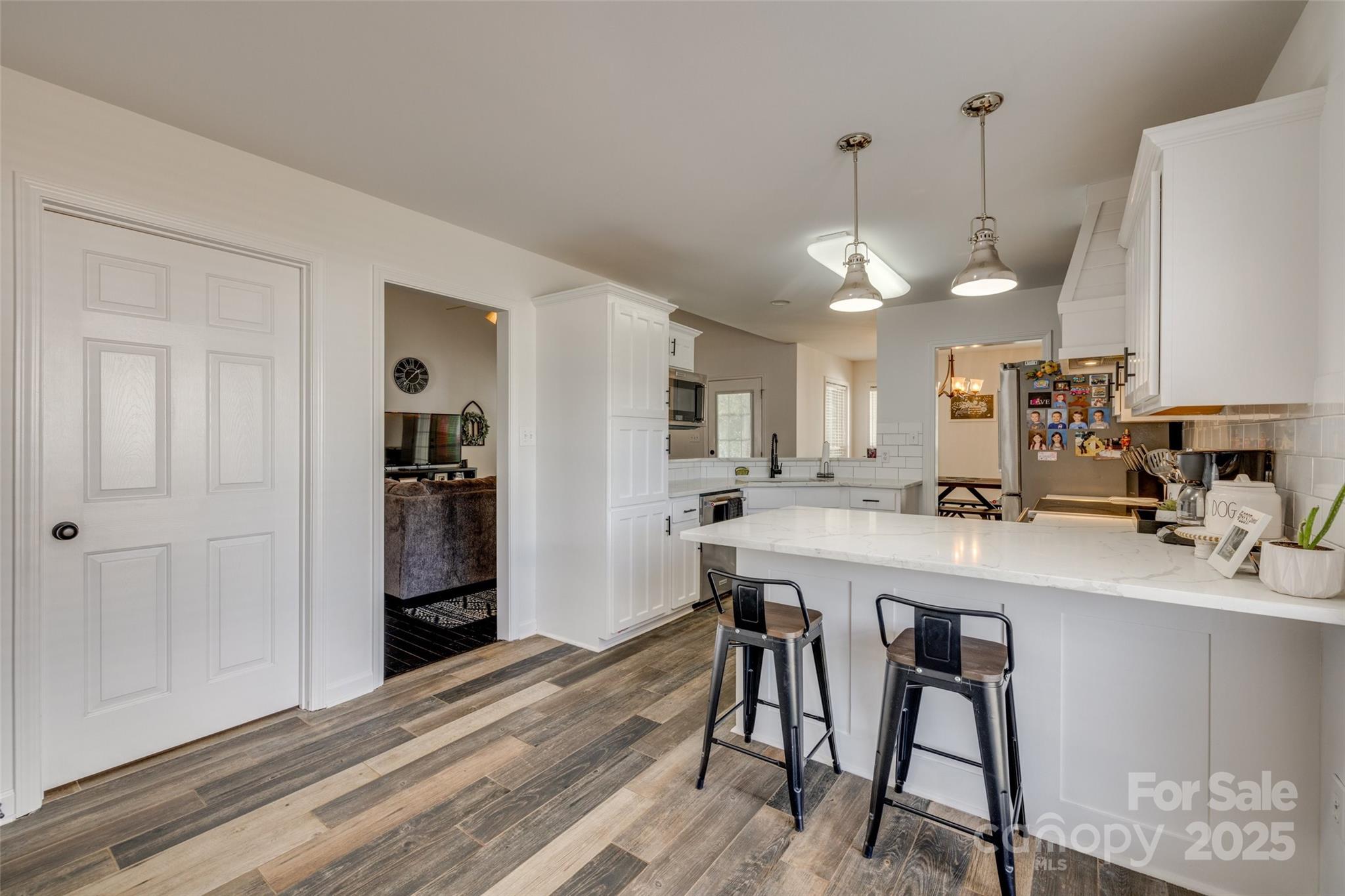 1140 Landsdown Drive Salisbury, NC 28147 - Photo 13 of 37 a kitchen with stainless steel appliances a dining table chairs and white cabinets