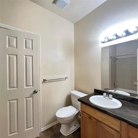 a view of an empty room with wooden floor and closet