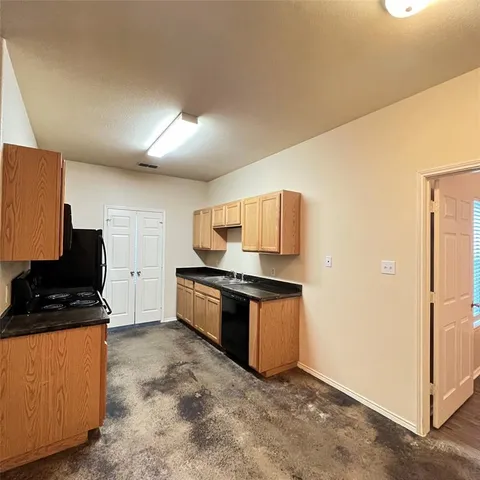 an empty room with wooden floor and fan