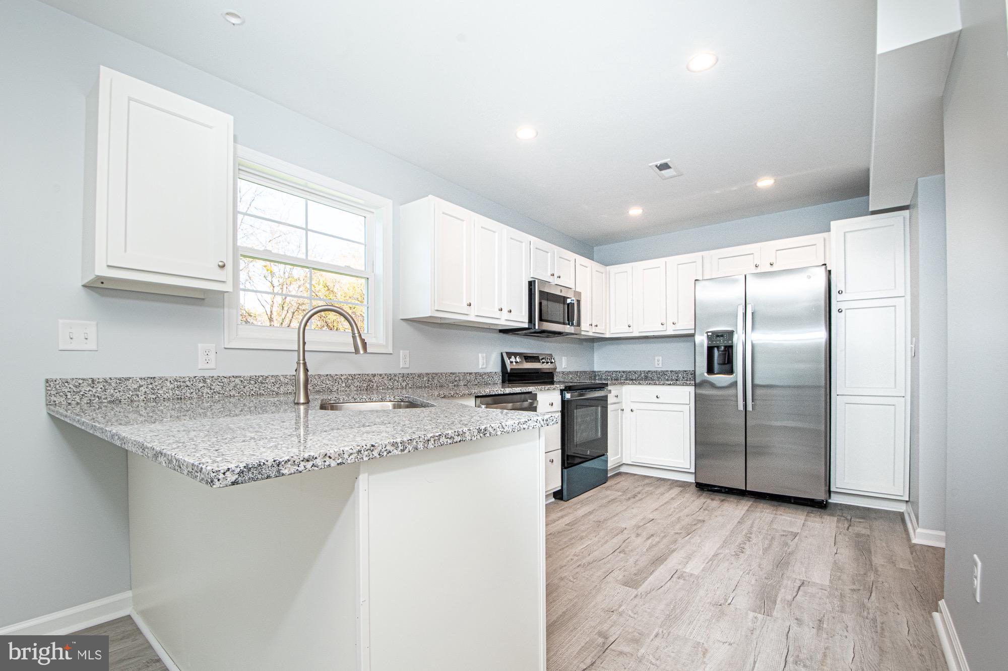 709 Ross Street Winchester, VA 22601 - Photo 7 of 40 a kitchen with a sink stainless steel appliances and white cabinets