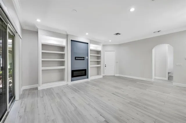 a view of empty room with wooden floor and window