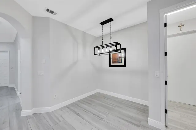 a view of a hallway with wooden floor and a ceiling fan