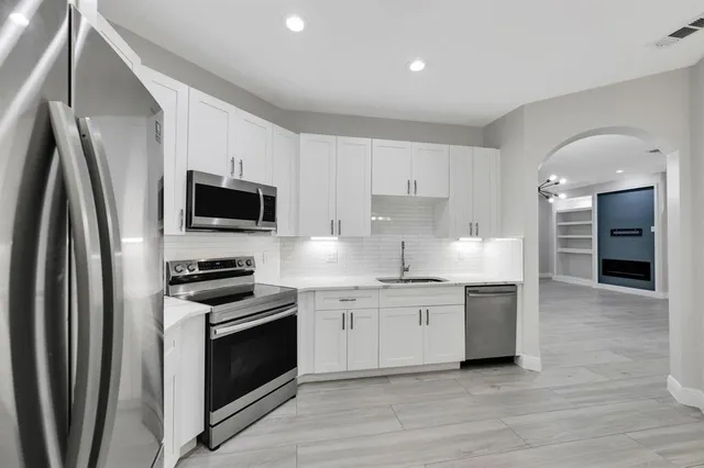 a kitchen with stainless steel appliances a stove a sink and a refrigerator