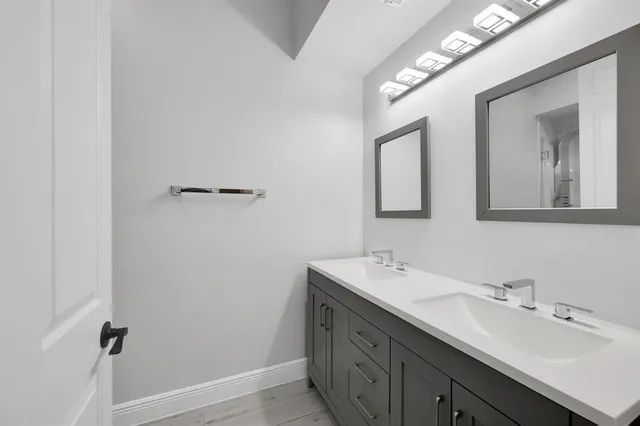 a bathroom with a double vanity sink and mirror