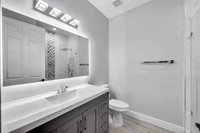 a bathroom with a toilet a sink and mirror