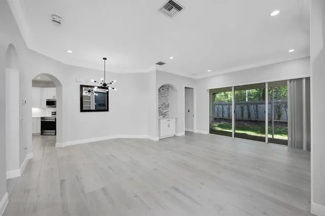 an empty room with wooden floor and a sink