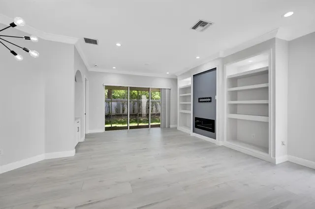 a view of an empty room with a window and fireplace
